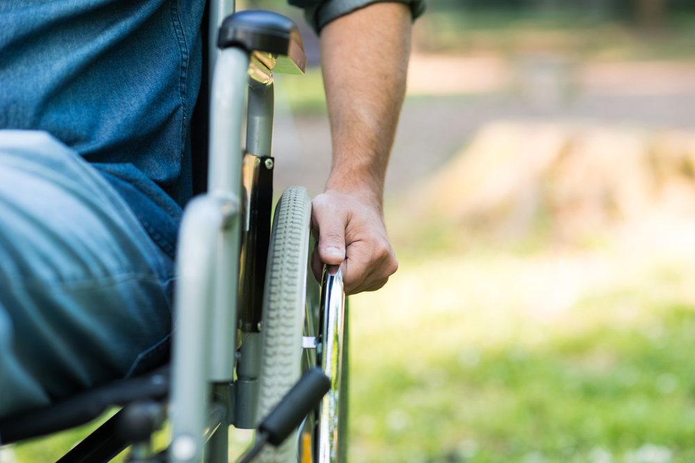 Detail Of a Man Using a Wheelchair in a Park.