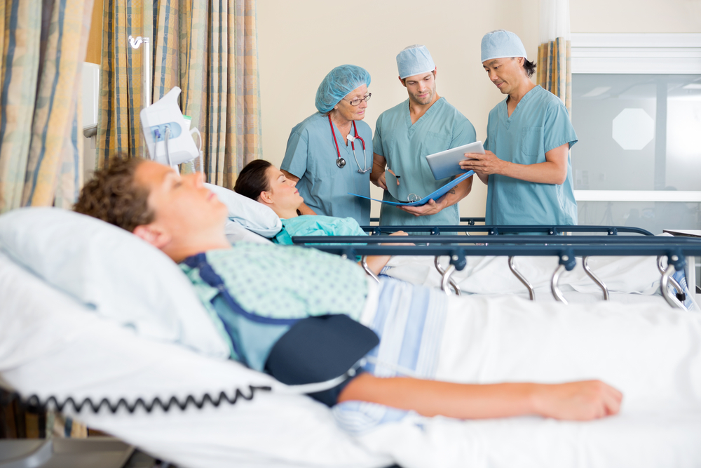 Team,Of,Nurses,With,Digital,Tablet,And,File,Discussing,Patient's