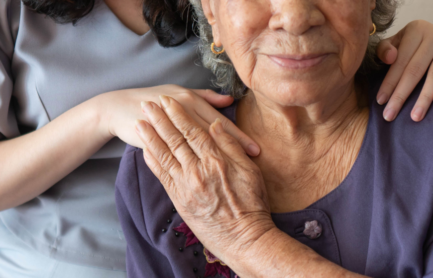 Friendly relationship between caregiver and happy Asian eldery woman during nursing at home.