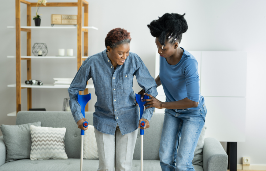 Older black woman at home using mobility devices and getting home care services from a caregiver