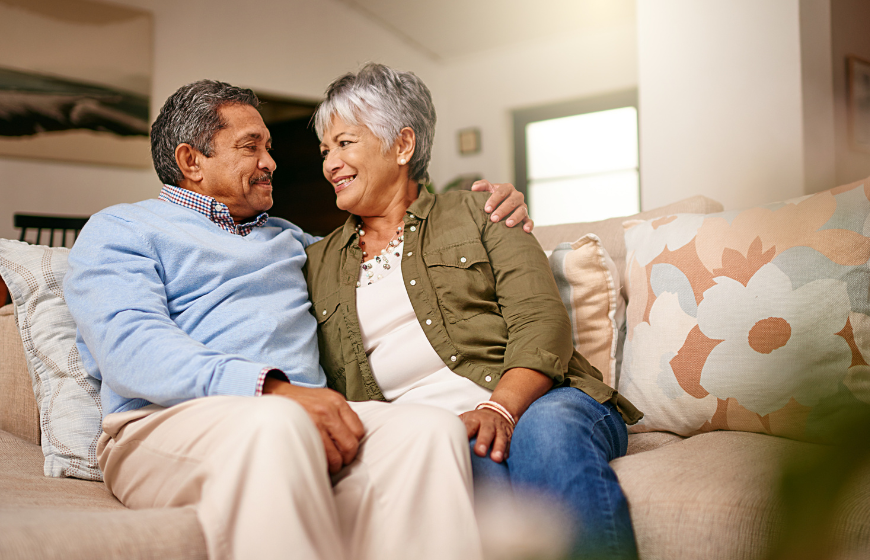 Older Hispanic couple relaxing on the sofa together home care for dementia