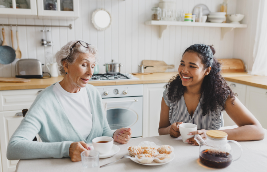 Caregiver enjoying self-care and tea with her grandmother at the kitchen table
